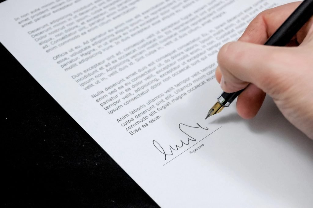 Mano firmando un contrato de arrendamiento, derechos ante un desalojo con un ESA