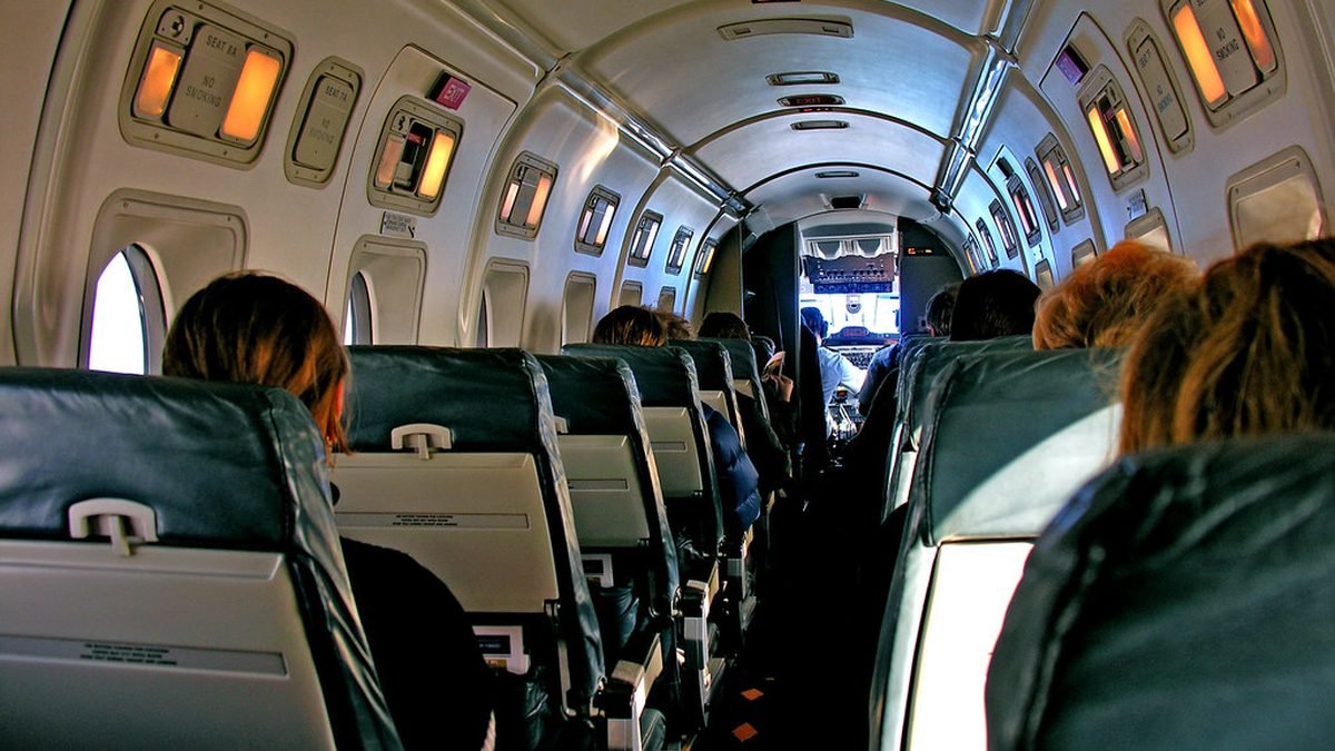 Crowded airplane cabin aisle, managing travel stress with an ESA
