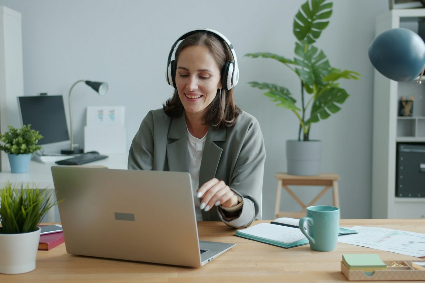 Licensed clinician with a headset on a telehealth video evaluation at her home office desk